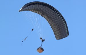 Airborne Systems DragonFly Army Cargo Delivery Parachute System flying with cargo. JPADS 10K System of Choice. Eliptical canopy carries loads up to 10,000 lbs. Max altitude 24,500 ft. View of canopy and payload from below.