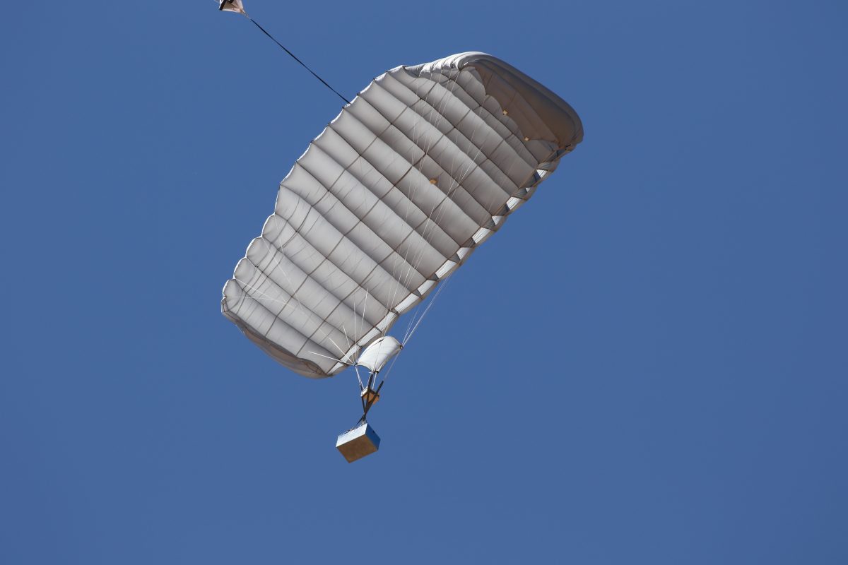 Airborne Systems - FC Mini Army cargo delivery parachute system. JPADS / GPADS: Guided Precision Aerial Delivery System. Carries 200-500 lbs. Max deployment altitude 24,500 ft. Military Cargo and inflated canopy, blue sky.