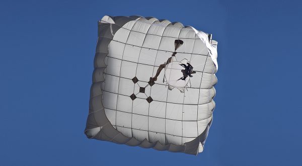 Airborne Systems - T-11 Static Line Troop Parachute System. T-11 Army Troop Parachute non-steerable for military jumpers. Carries an all-up weight of 400 lbs. Max deployment altitude of 7500 ft. View from directly below deployed canopy, blue sky. Military & space textile manufacturing & design. Army & space parachute canopies, aerial delivery (GPADS/JPADS). Aircraft & spacecraft deceleration systems.