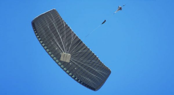 Airborne Systems DragonFly Army Cargo Delivery Parachute System flying with cargo. JPADS 10K System of Choice. Eliptical canopy carries loads up to 10,000 lbs. Max altitude 24,500 ft. View of canopy and payload from below.