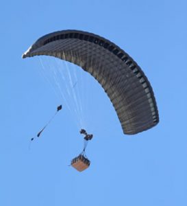 Airborne Systems FireFly Army Cargo Delivery Parachute System. JPADS 2K System of Choice. Carries unmanned loads up to 2,200 lbs. Max deployment altitude 24,500 ft. drop. Deployed canopy with cargo box from below.