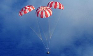 Airborne Systems space parachute & inflatable systems. Military-grade deceleration, airbag landing, aerospace recovery, personnel & cargo delivery parachute systems. Entry, Descent & Landing System (EDLS) development for space and high altitude applications. Recovery system for the Discoverer XIII reentry capsule. Three red and white canopies with blue sky.